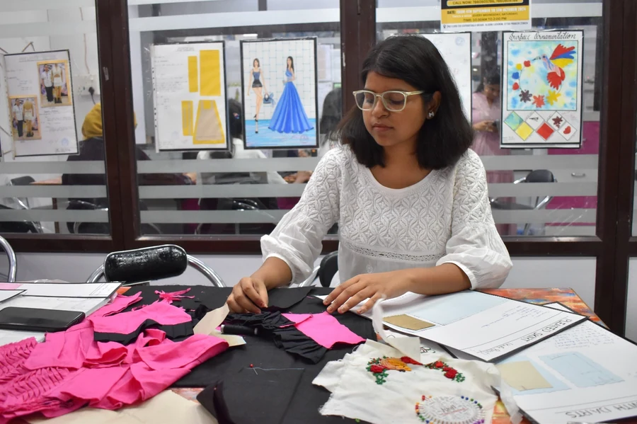 Wisdom College student working on garment construction